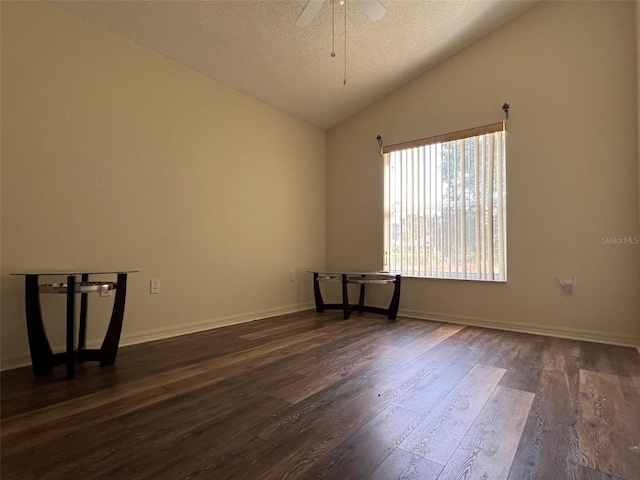 empty room featuring lofted ceiling, ceiling fan, a textured ceiling, and dark hardwood / wood-style flooring