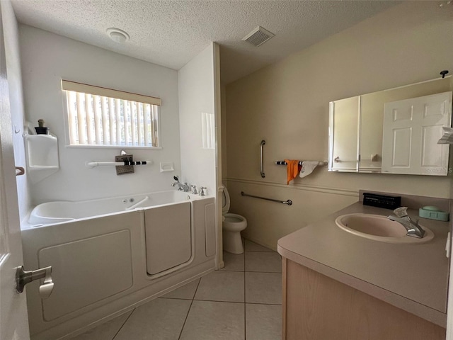 bathroom with a bathtub, a textured ceiling, toilet, vanity, and tile patterned flooring