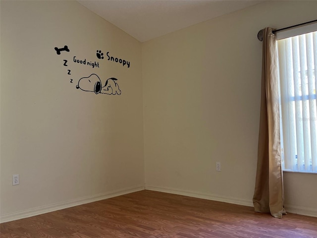 empty room with vaulted ceiling and wood-type flooring