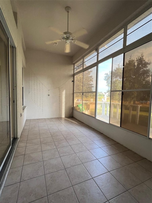 unfurnished sunroom with ceiling fan