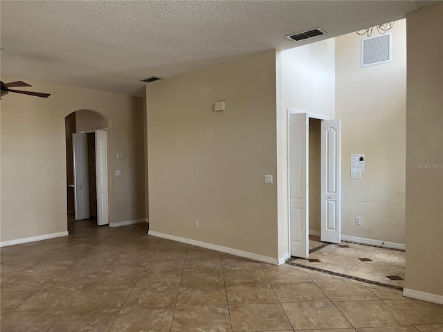 tiled empty room with a textured ceiling and ceiling fan