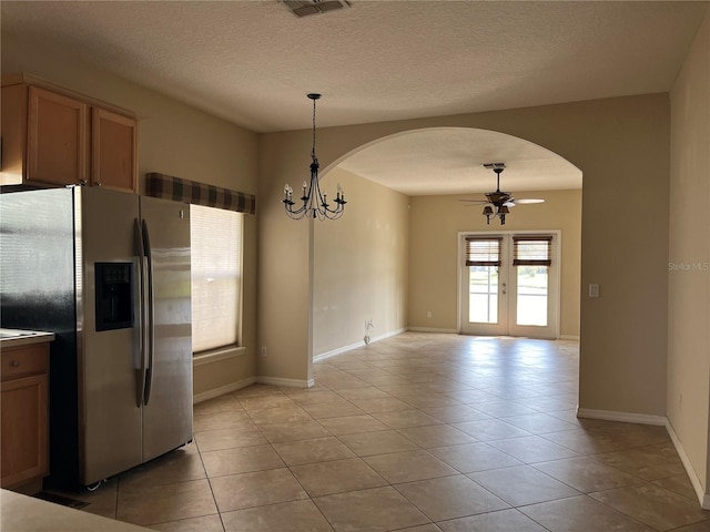 kitchen featuring french doors, ceiling fan with notable chandelier, stainless steel fridge, decorative light fixtures, and light tile patterned flooring