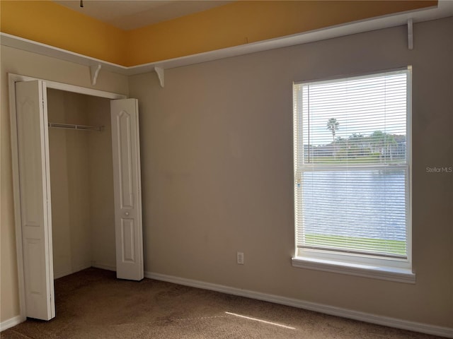 unfurnished bedroom featuring carpet flooring, a closet, and multiple windows