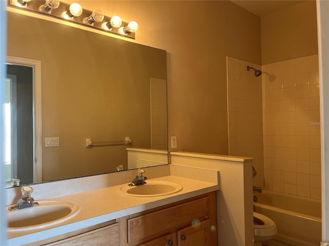 full bathroom featuring vanity, tiled shower / bath combo, and toilet