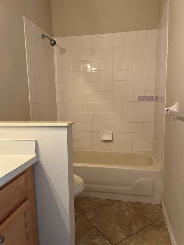 full bathroom featuring tile patterned flooring, vanity, tiled shower / bath combo, and toilet