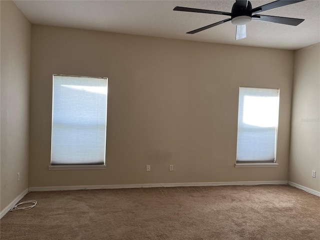 carpeted spare room featuring ceiling fan