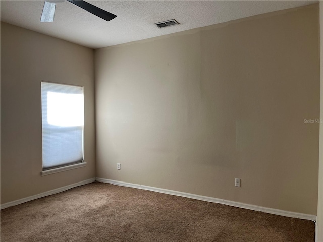 unfurnished room featuring ceiling fan, carpet, and a textured ceiling