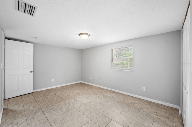 unfurnished room with a textured ceiling