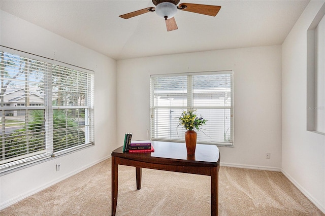 carpeted home office featuring ceiling fan