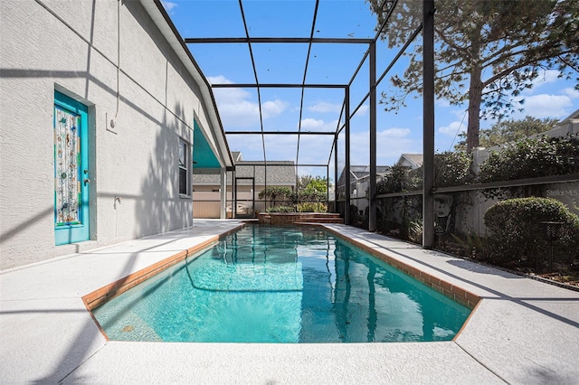 view of pool with glass enclosure