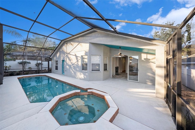 view of pool with an in ground hot tub, glass enclosure, ceiling fan, and a patio area