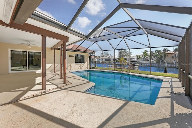 view of swimming pool featuring a water view, a patio, a lanai, and ceiling fan