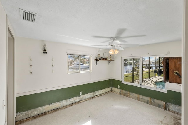 unfurnished room with a textured ceiling and ceiling fan