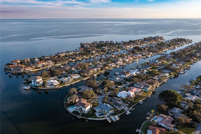 aerial view at dusk featuring a water view