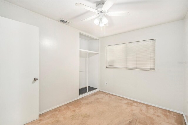 empty room featuring light colored carpet and ceiling fan