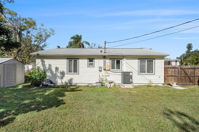 back of house featuring a yard, central AC, and a shed