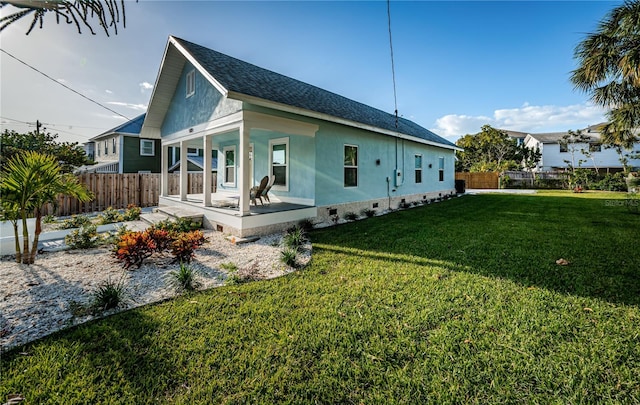 view of side of property featuring covered porch and a yard