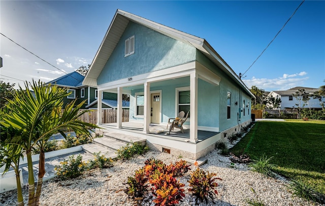 view of front of home featuring covered porch and a front lawn