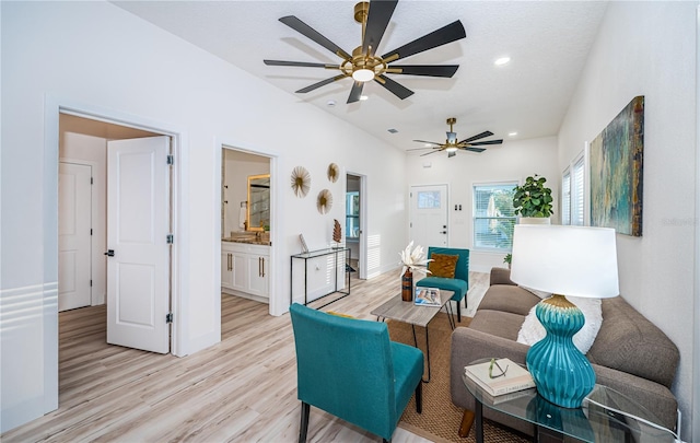 living room featuring light hardwood / wood-style floors and ceiling fan