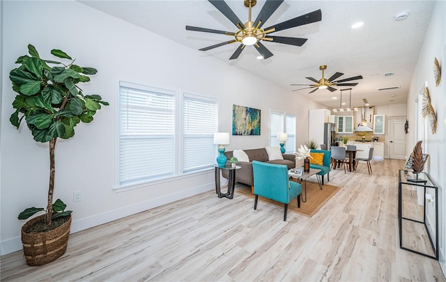 living room featuring ceiling fan, a textured ceiling, and light wood-type flooring