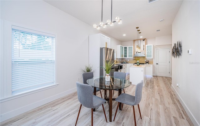 dining space featuring an inviting chandelier and light wood-type flooring