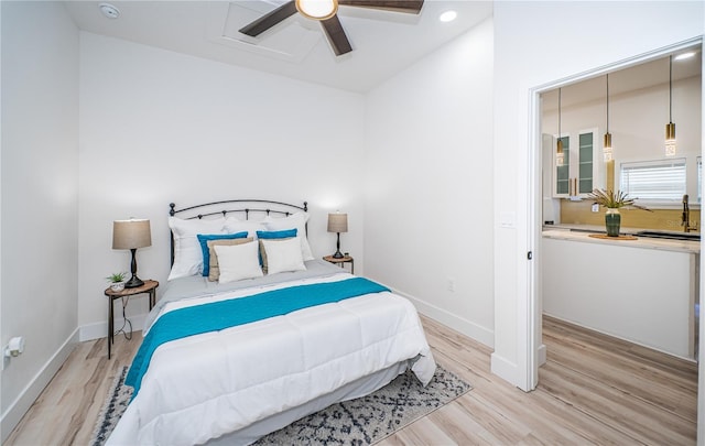 bedroom with ceiling fan, vaulted ceiling, and light hardwood / wood-style flooring