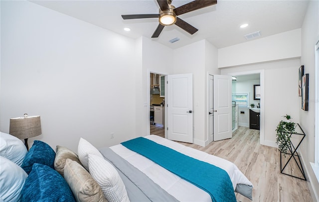 bedroom featuring ensuite bath, light hardwood / wood-style flooring, and ceiling fan