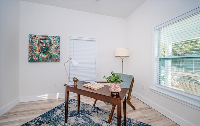 office with light hardwood / wood-style floors and plenty of natural light