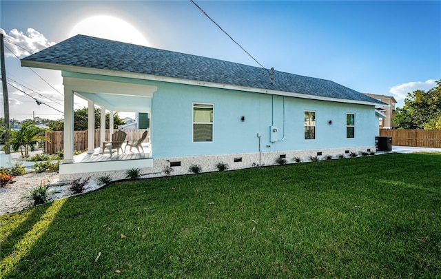 rear view of house featuring a patio, a yard, and central AC unit