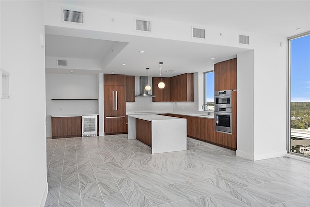 777 3rd Ave N Unit 1203, Saint Petersburg, FL 33701 - kitchen featuring modern cabinets, wall chimney range hood, a center island, light countertops, and a sink