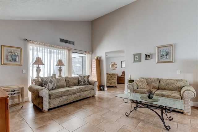 living room featuring light tile patterned flooring and high vaulted ceiling