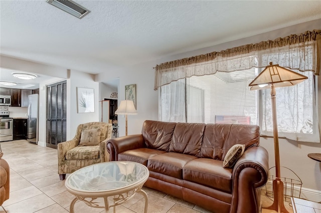 tiled living room featuring a textured ceiling