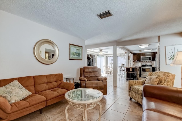 tiled living room featuring ceiling fan and a textured ceiling