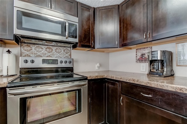 kitchen featuring light stone countertops, dark brown cabinetry, and stainless steel appliances