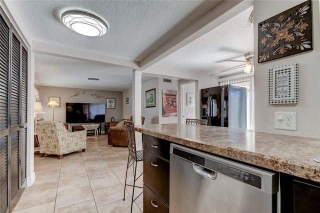 kitchen featuring black fridge, stainless steel dishwasher, a textured ceiling, ceiling fan, and light tile patterned floors