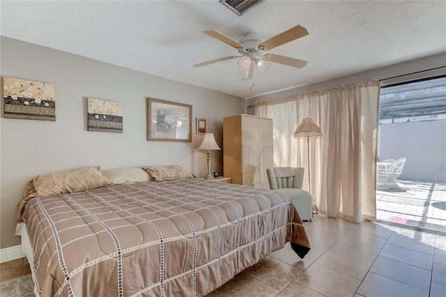 tiled bedroom with a textured ceiling and ceiling fan