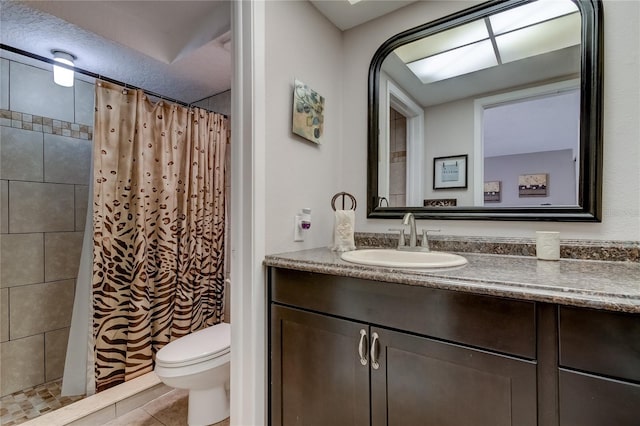 bathroom with tile patterned floors, vanity, toilet, and walk in shower