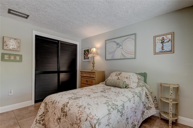 tiled bedroom with a textured ceiling