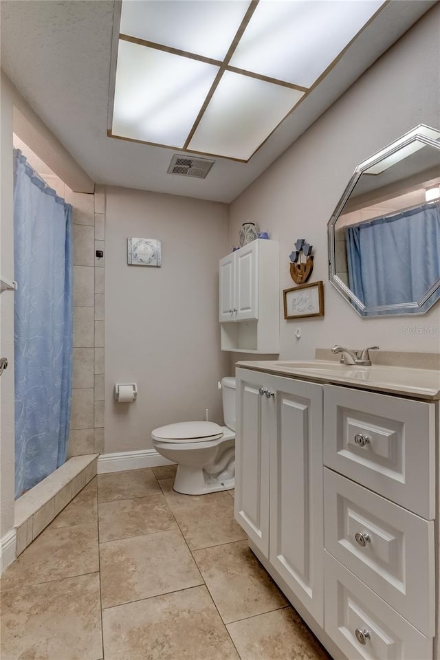 bathroom with tile patterned floors, vanity, toilet, and walk in shower