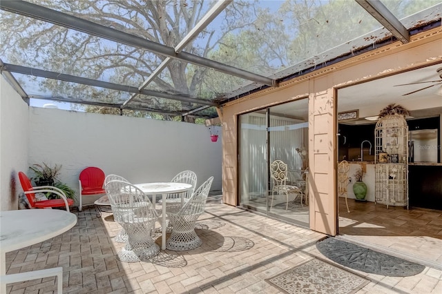 view of patio / terrace featuring a lanai and sink