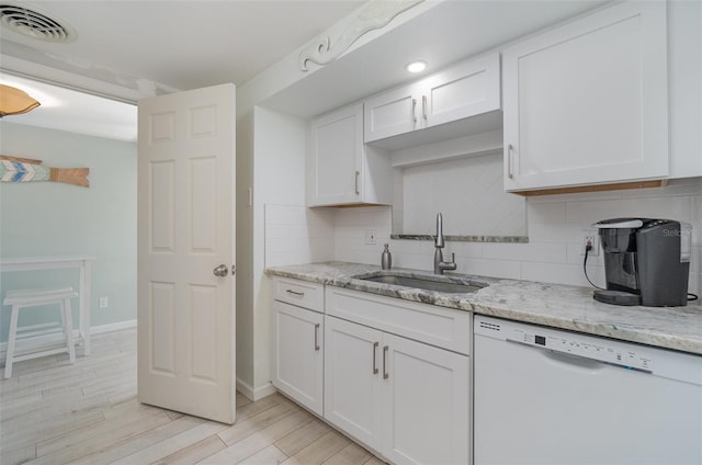 kitchen with white cabinetry, sink, and white dishwasher