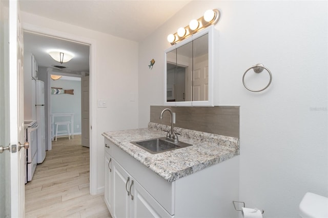 bathroom with vanity, toilet, and wood-type flooring