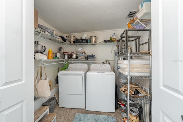 laundry area featuring a textured ceiling and washing machine and clothes dryer