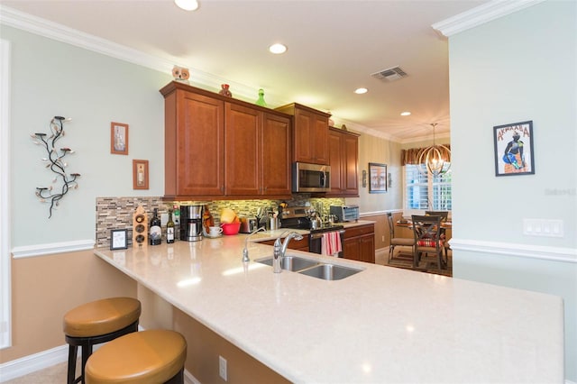 kitchen with kitchen peninsula, stainless steel appliances, crown molding, and a breakfast bar