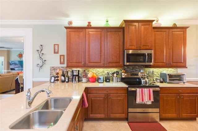 kitchen featuring stainless steel appliances, sink, crown molding, light tile patterned flooring, and tasteful backsplash