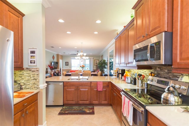 kitchen featuring appliances with stainless steel finishes, sink, ornamental molding, kitchen peninsula, and decorative backsplash