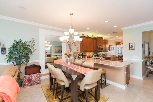 dining area with ornamental molding, sink, and light tile patterned floors