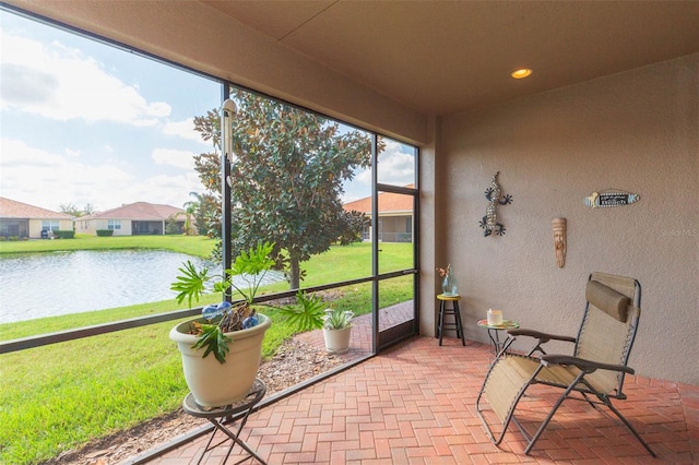 sunroom featuring a water view