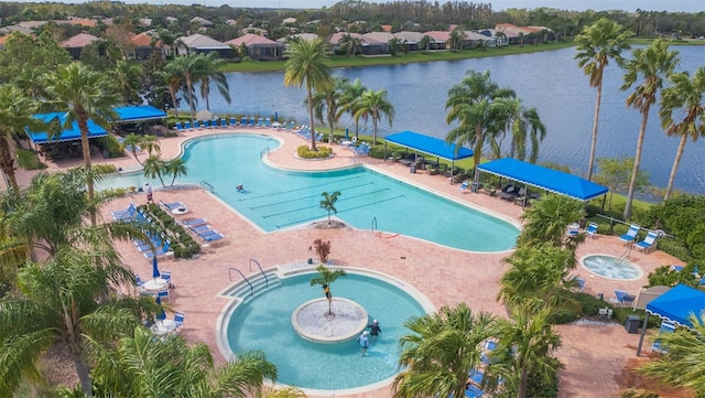 view of swimming pool with a community hot tub, a water view, and a patio