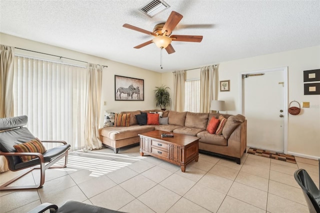 tiled living room featuring a textured ceiling and ceiling fan